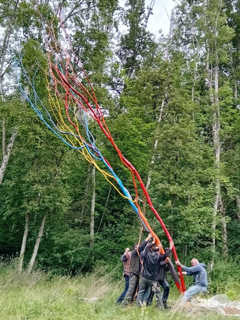 L'équipe salariée installe l'arbre coloré à l'entrée du domaine de Flotin